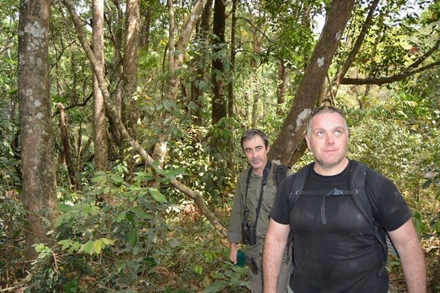 Stuart and Ash hiking through the forest to check camera traps