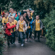 A group of school children run along a path at Chester Zoo