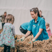 A member of staff at Chester Zoo teaches a child how to build a hedgerow