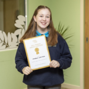 Teenage girl with long brown hair hold certificate