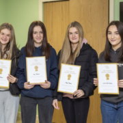 Four teenage girls hold certificates