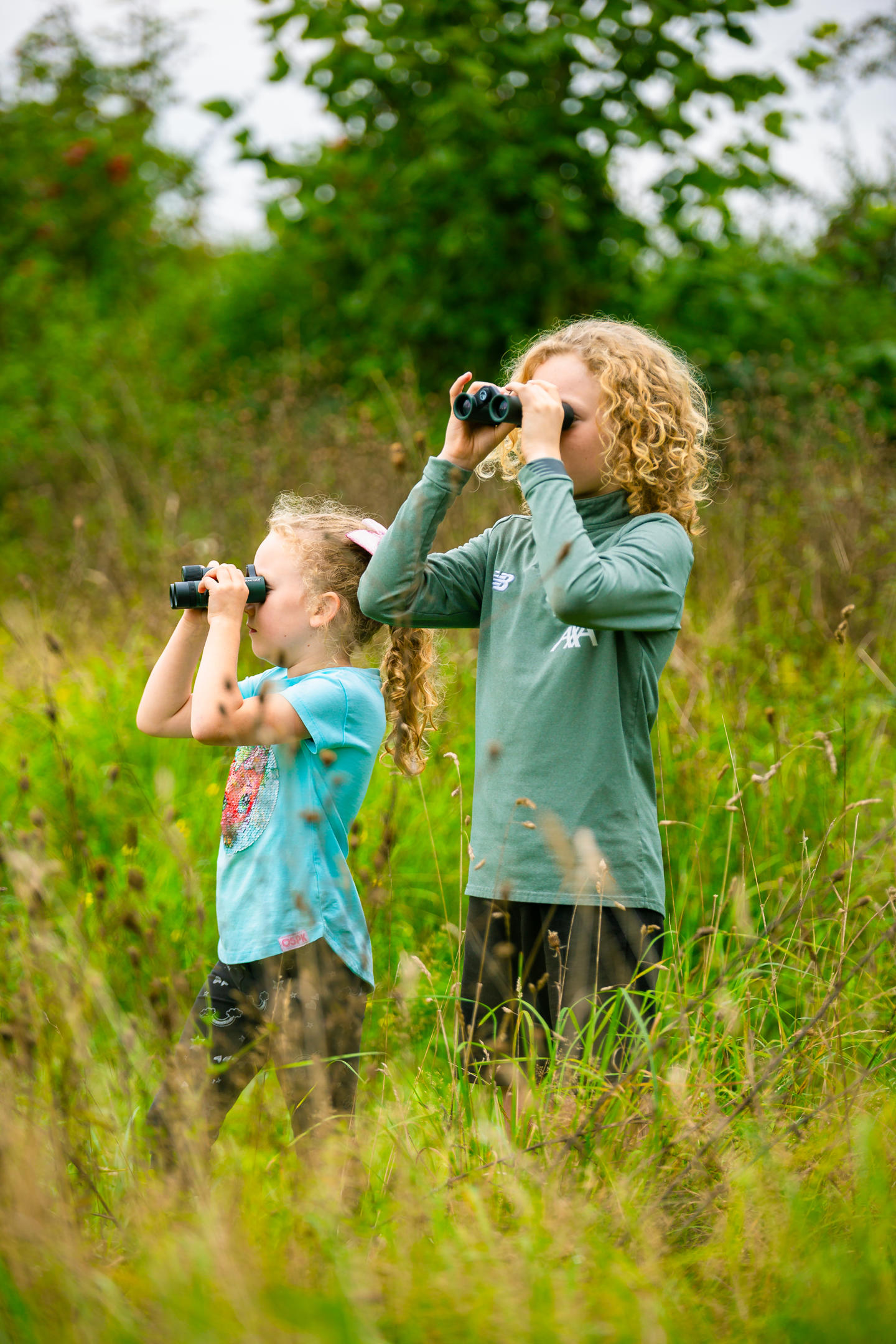 Two Children Looking Through Binoculars At The Wildlife Connections