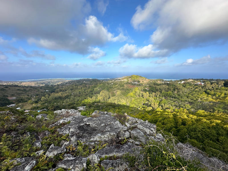 Image shows a view across Gran Montagne national park looking out over a rock escarpment across to forest