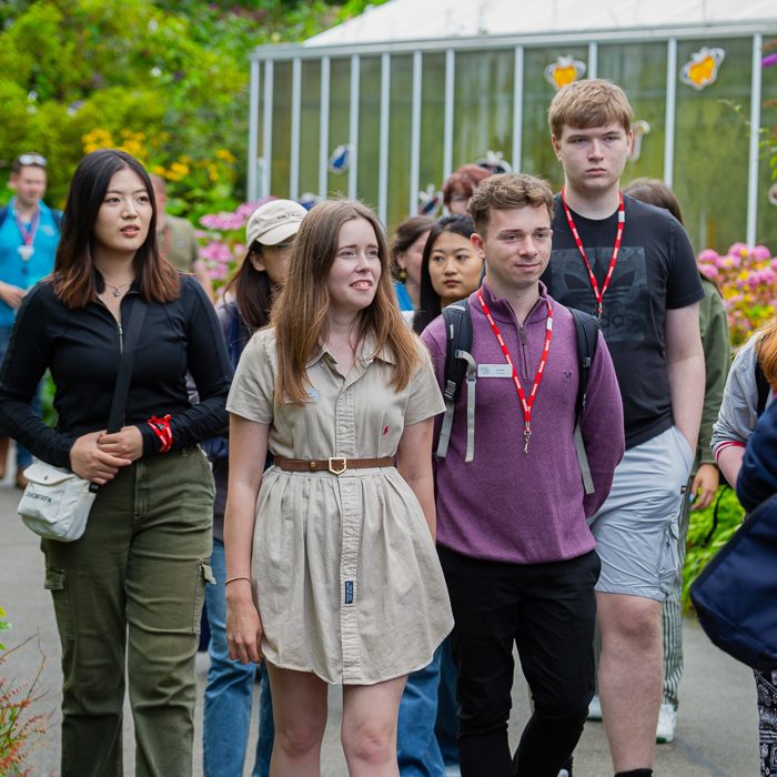 Photo shows young people from the Chester Zoo youth board gathering by the butterfly house for a social.